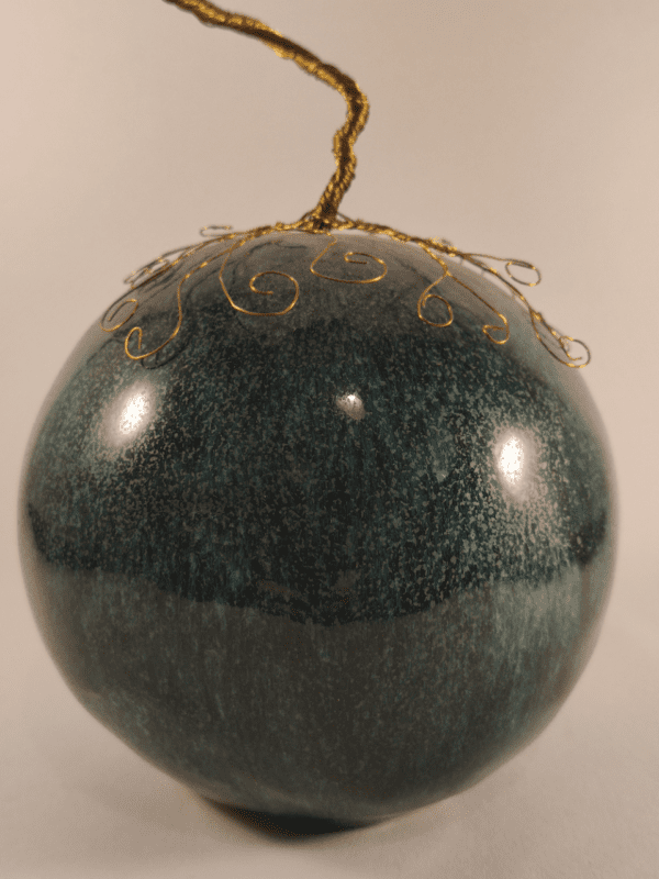 arbre de vie en fil de fer doré sur boule en céramique émaillée bleue. Vue de près de la boule