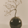 Arbre de vie en fil de fer doré sur une boule de céramique émaillée verte.