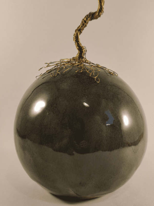 arbre de vie en fer doré posé sur une boule de céramique émaillée verte avec des effets marrons. Vue de près sur la boule