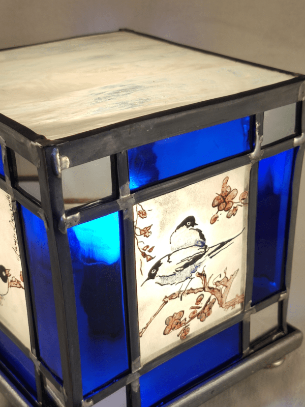 Lampe vitrail Azulero en forme de cube. Dessins d'oiseaux sur les quatre faces et bordure en verre bleu et miroir
