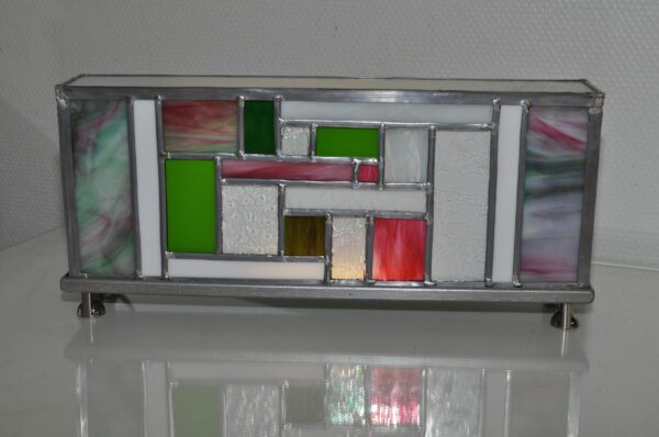 lampe Laïka allumée rectangulaire d'inspiration Mondrian avec des couleurs rose, vert et blanc. Vue de face