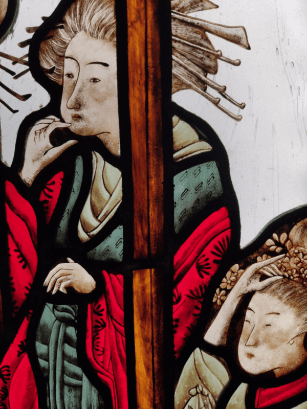 vitrail inséré dans une boite lumineuse représentant des Geishas derrière une fenêtre en bois. Elles observent quelque chose. Le vitrail s'intitule "le retour"