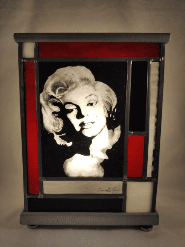 Lampe vitrail Marilyne. Portrait de Marilyne Monroe avec des bords rouges et noirs vue de face