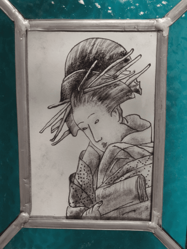 Petit médaillon Mini Tyne représentant un portrait de geisha peint à la grisaille noire avec un liseré de vert bleu