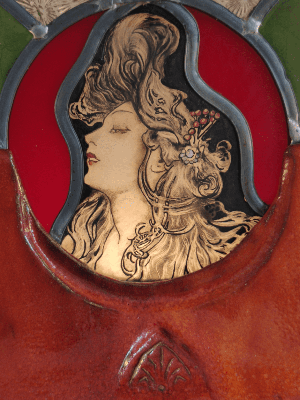 vue du portrait dans le médaillon de la lampe en vitrail d'inspiration Mucha avec une base en terre émaillée rouge