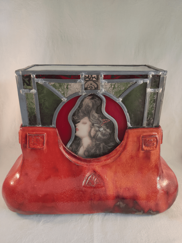 présentation de face de la lampe éteinte en vitrail d'inspiration Mucha sur une base en céramique émaillée rouge