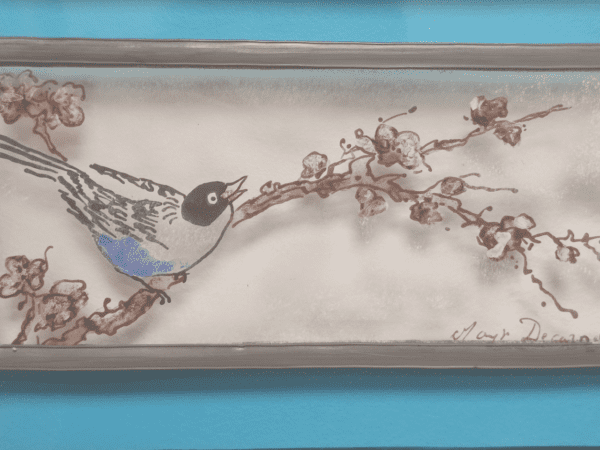 Médaillon Pita de forme rectangulaire. Petit oiseau posé sur une branche de cerisier en fleur avec une bordure en verre bleu clair