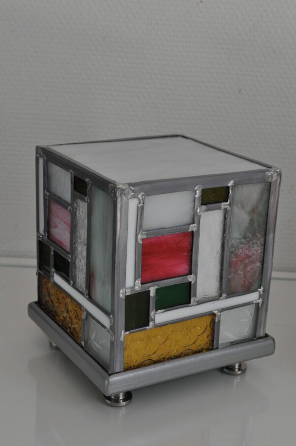 lampe Tyni éteinte en forme de cube d'inspiration Mondrian en vert jaune et rose. Cette lampe peut servir de lampe de chevet